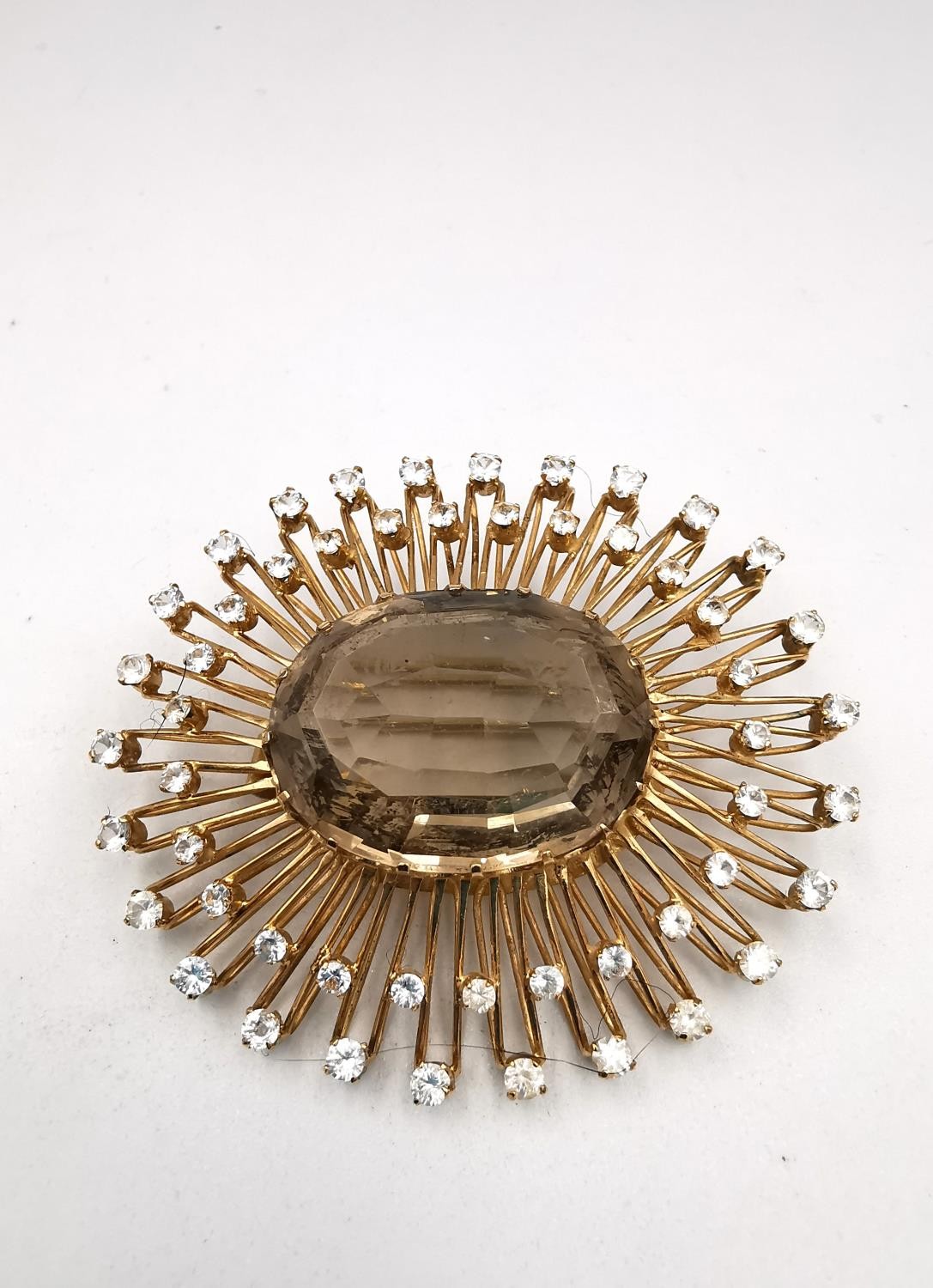 A yellow metal (tests as 9ct) bespoke made sunburst brooch/pendant, set to centre with an oval mixed