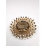 A yellow metal (tests as 9ct) bespoke made sunburst brooch/pendant, set to centre with an oval mixed