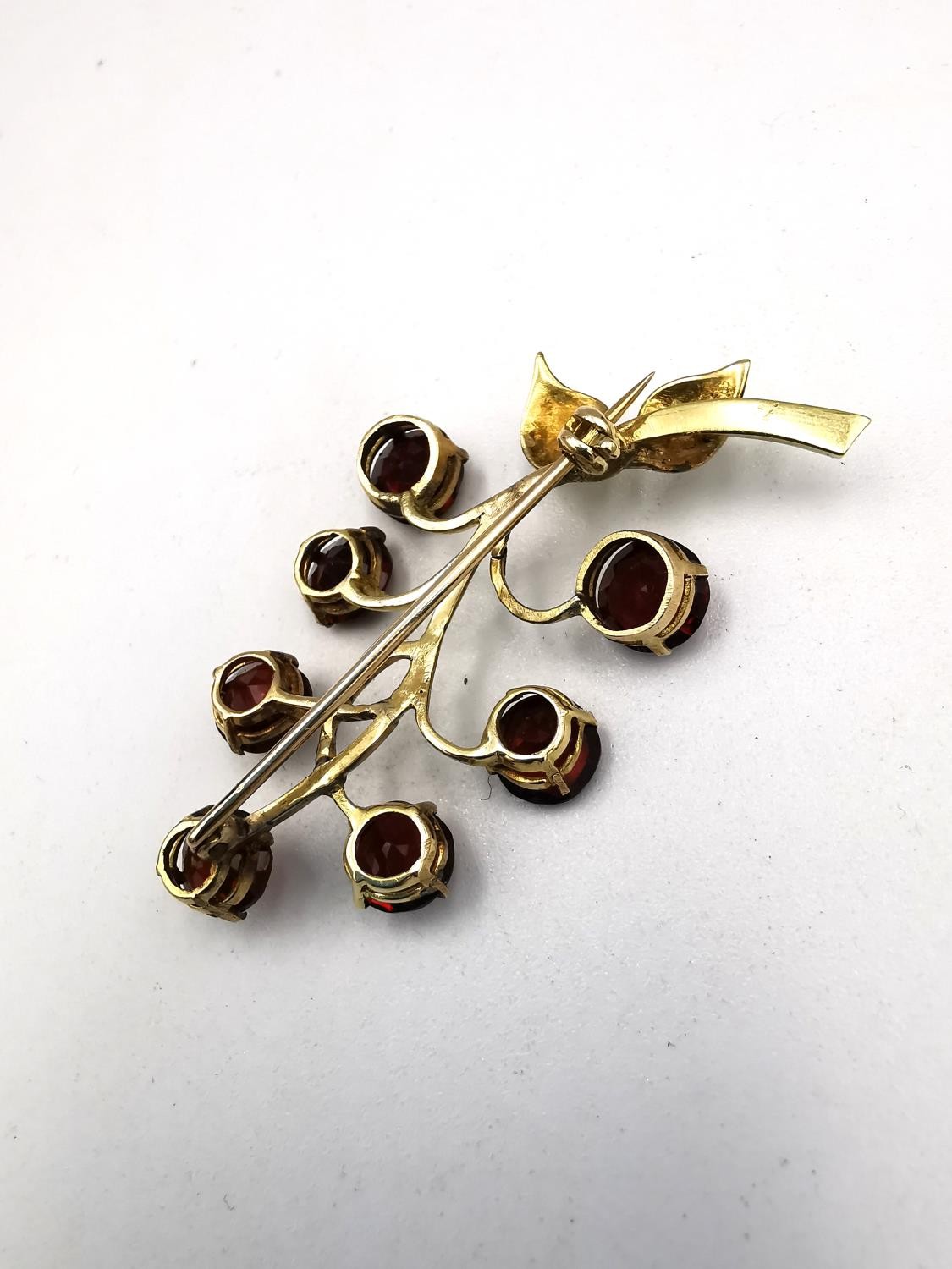 A yellow metal (tests as 9ct) garnet set berry sprig brooch along with a pink metal (tests as 9ct) - Image 4 of 13