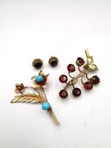 A yellow metal (tests as 9ct) garnet set berry sprig brooch along with a pink metal (tests as 9ct)