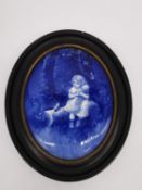 A framed 19th century Royal Doulton oval blue and white ceramic wall plaque decorated with girl with