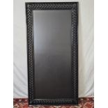 A contemporary carved and lacquered full height mirror. H.200 W.100cm.