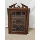 A Georgian style oak hanging corner cabinet. H.81 W.54 D.31cm.