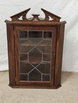 A Georgian style oak hanging corner cabinet. H.81 W.54 D.31cm.