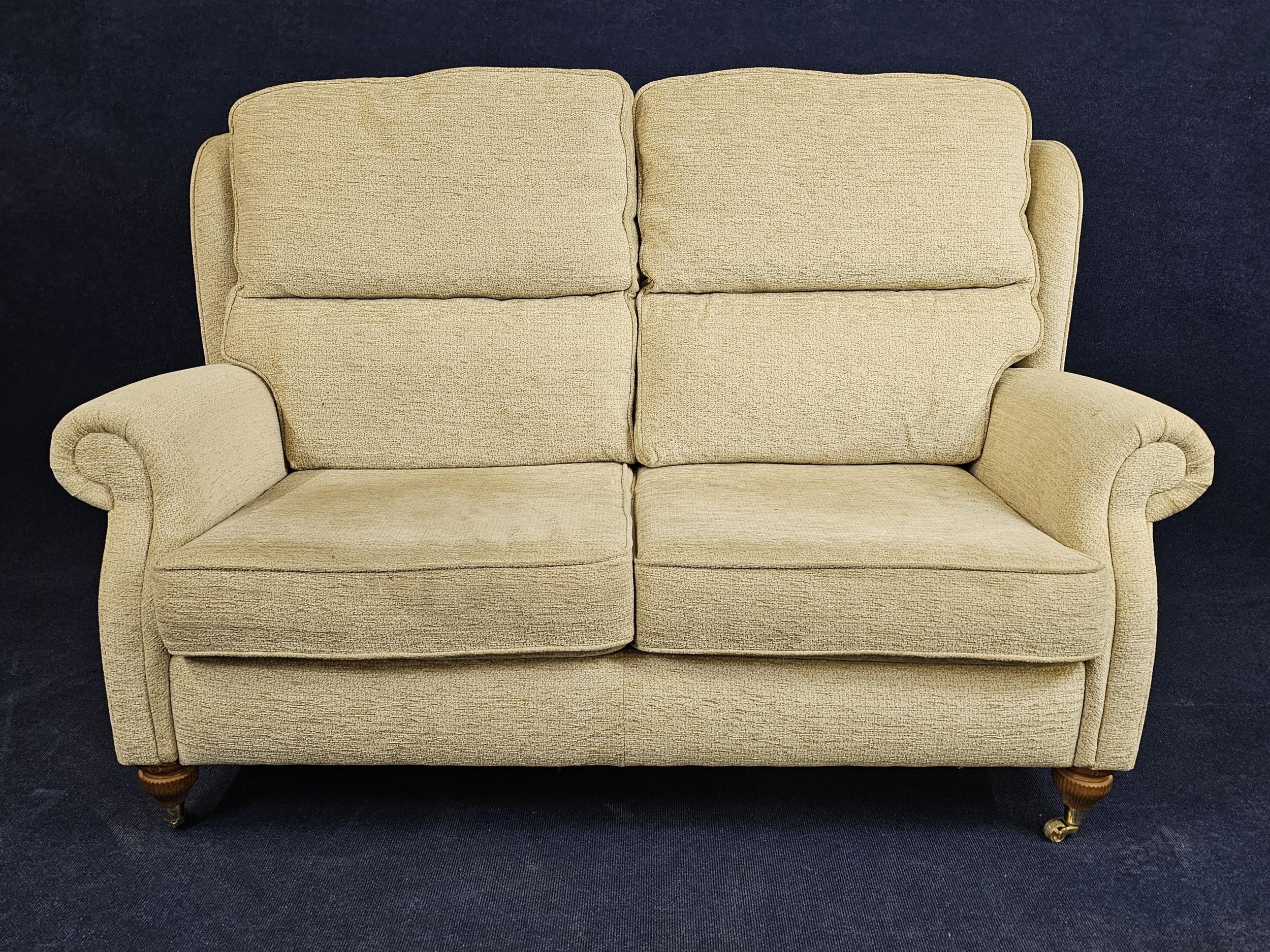 A contemporary sofa on turned supports with brass casters. H.105 W.150 D.90cm.