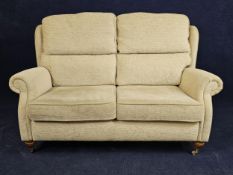 A contemporary sofa on turned supports with brass casters. H.105 W.150 D.90cm.