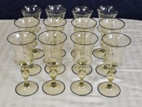 A set of twelve Venetian amber hand blown glass wine glasses with black rims. H.20cm.