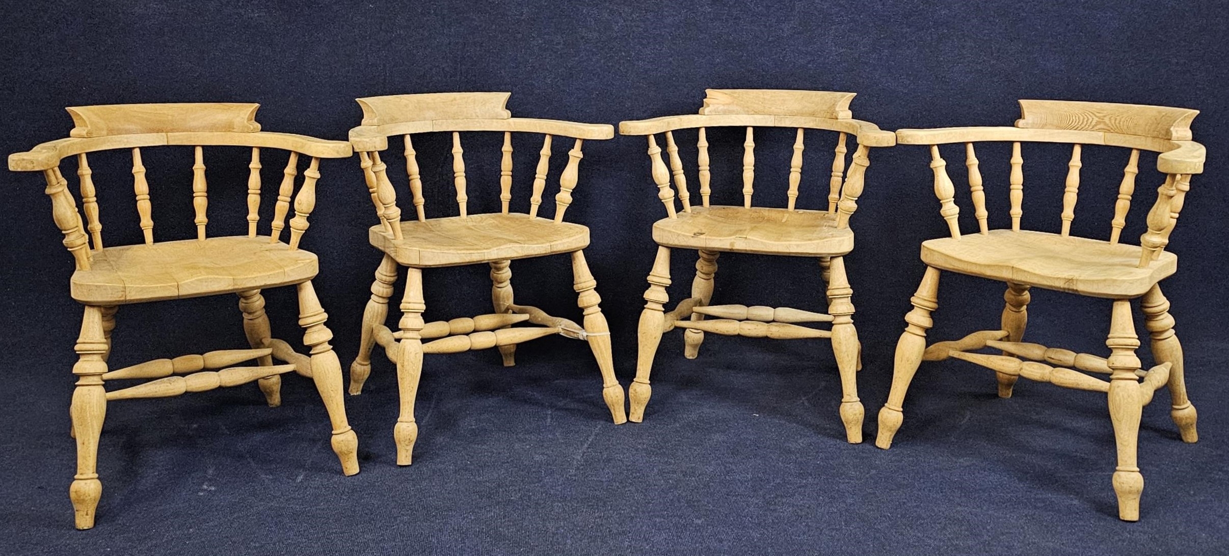 A set of four pitch pine smokers bow back armchairs.