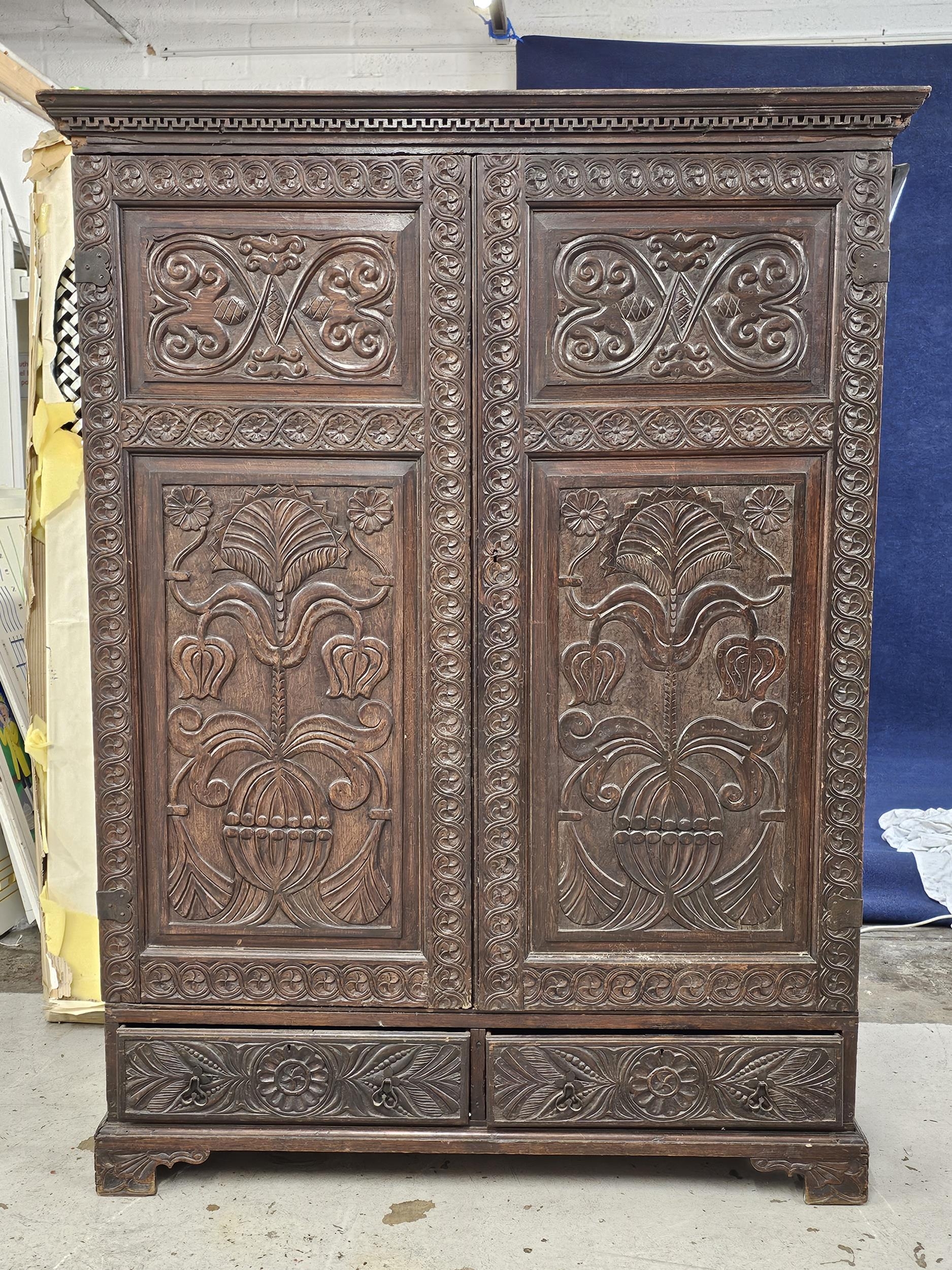 An 18th century carved oak hall cupboard fitted with base drawers on bracket feet. H.188 W.132 D.
