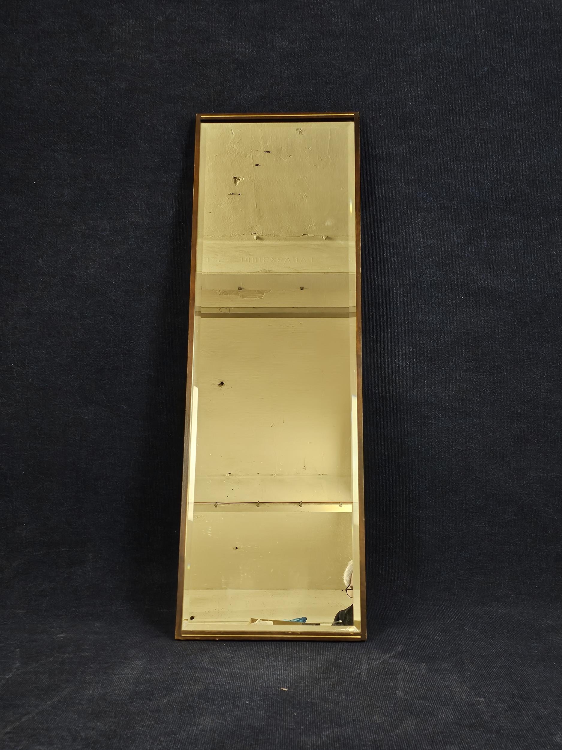 A contemporary bevelled wall mirror. H.125 W.42cm.