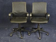 A pair of contemporary office desk armchairs.