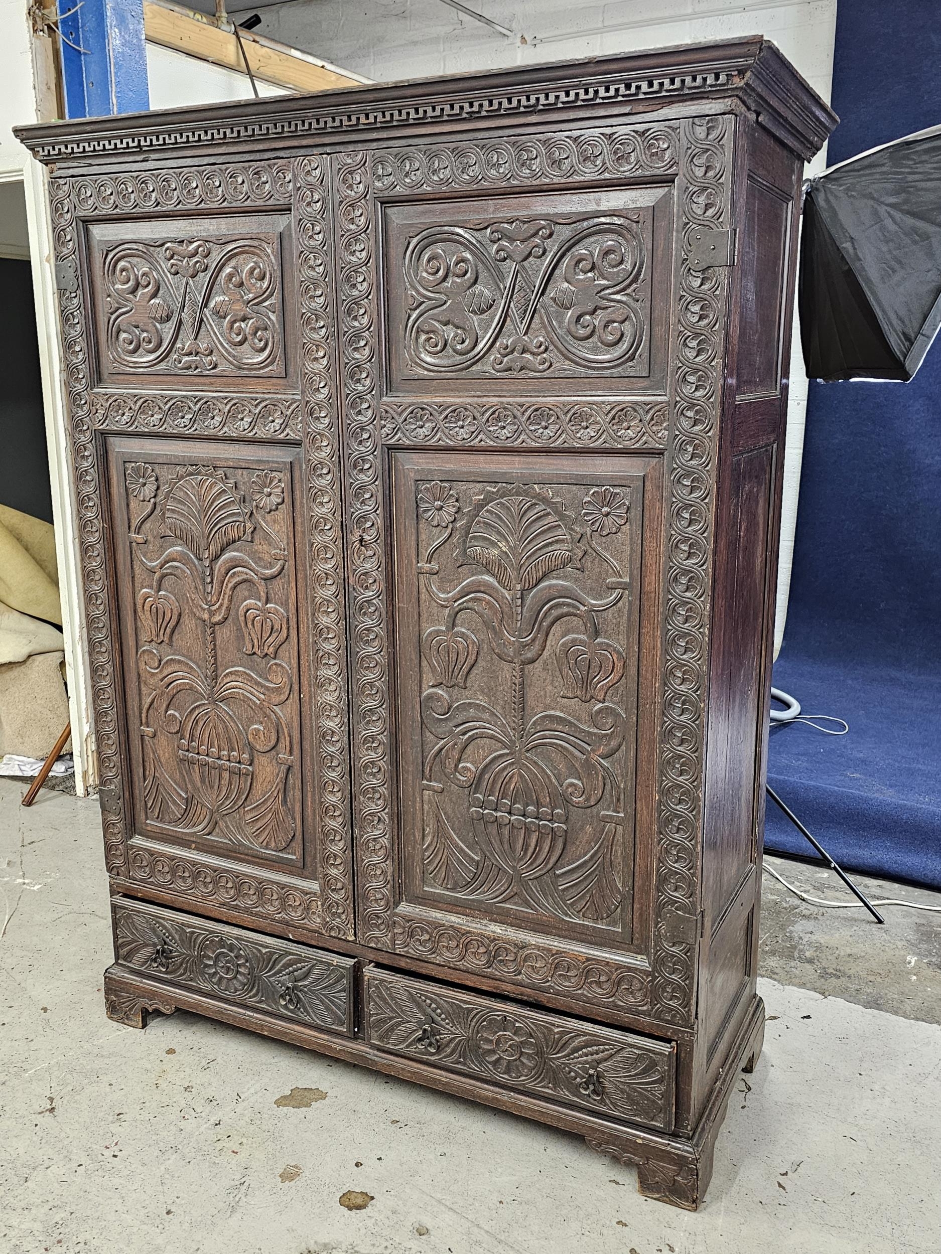 An 18th century carved oak hall cupboard fitted with base drawers on bracket feet. H.188 W.132 D. - Image 2 of 5