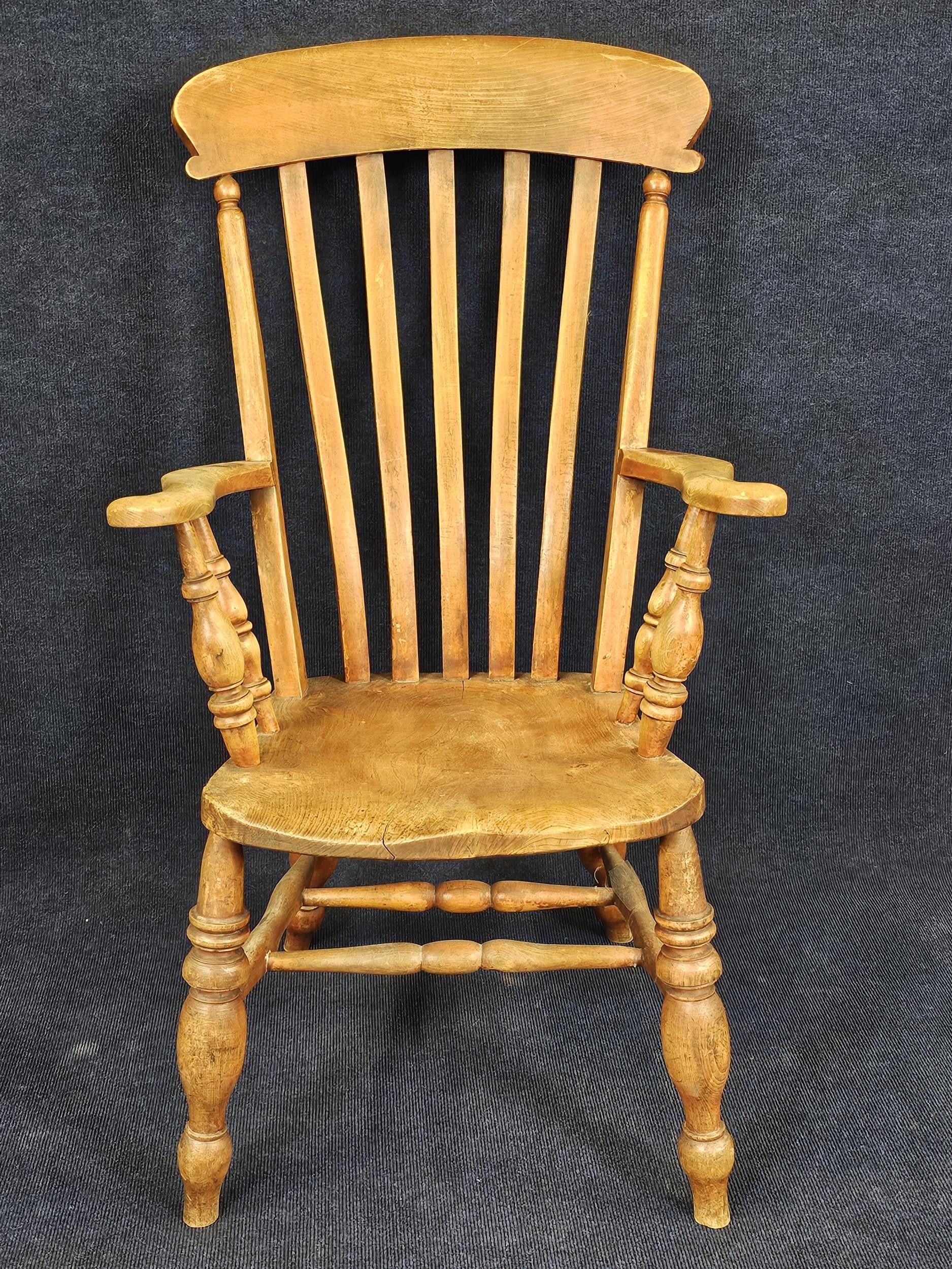 A 19th century elm seated stick back kitchen armchair. H.115 W.60 D.65cm.