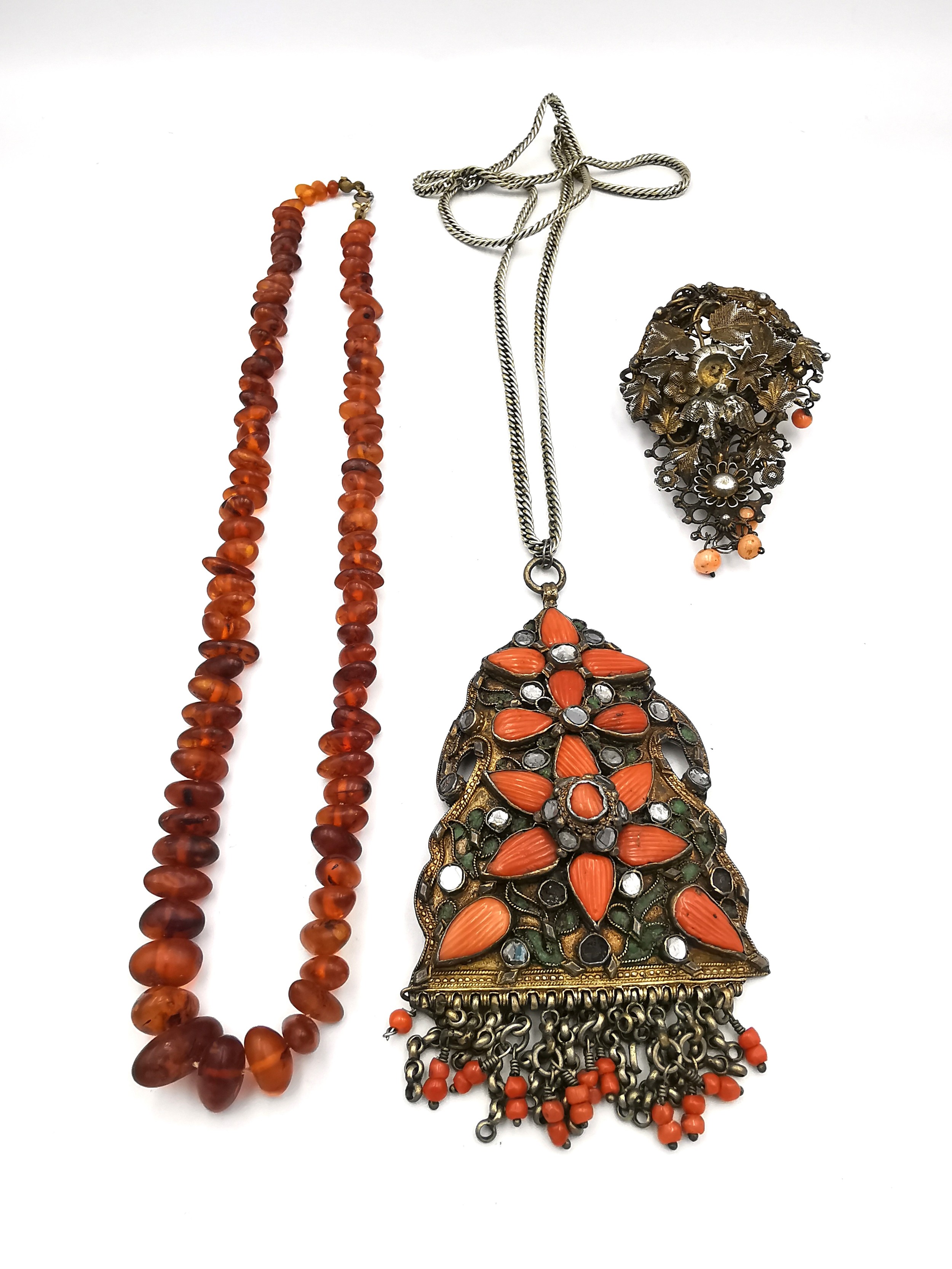 A vintage Baltic amber pebble bead necklace, a filigree and wirework coral bead brooch with a bird