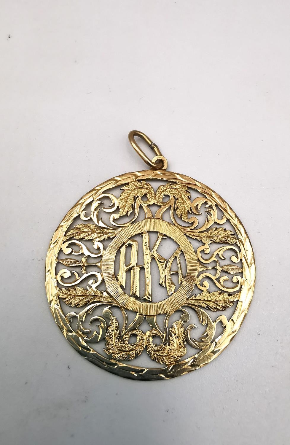 A gold plated pierced mongram pendant with acanthus leaf detailing. Diameter 4cm. Weight 5.06g - Image 2 of 5