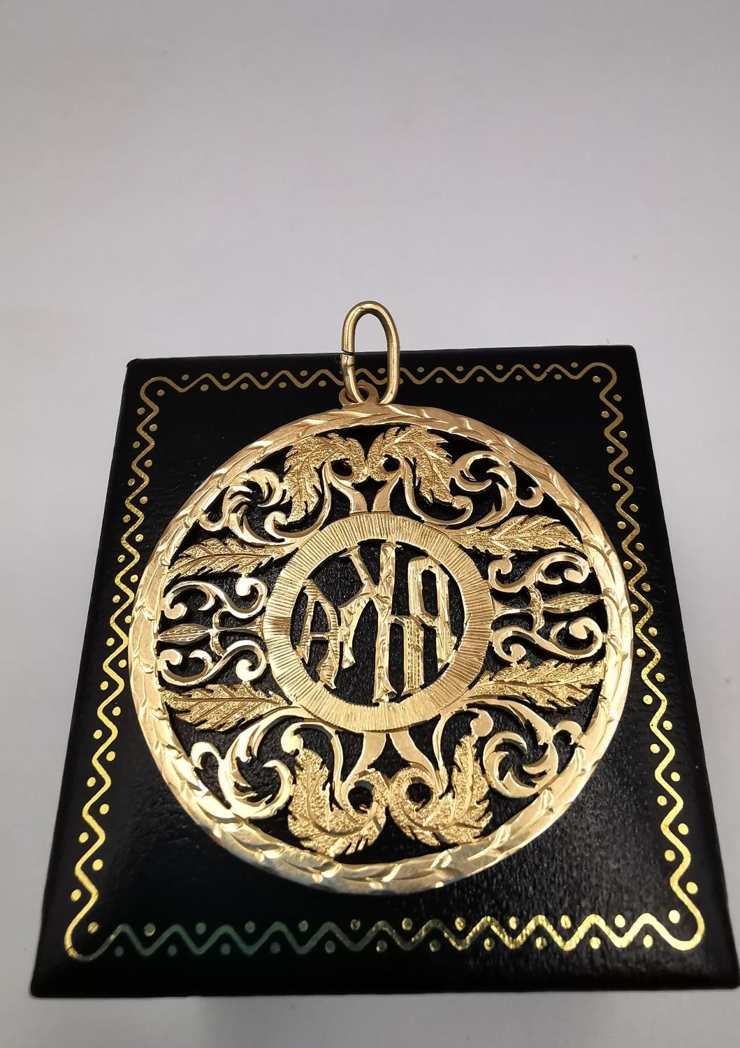 A gold plated pierced mongram pendant with acanthus leaf detailing. Diameter 4cm. Weight 5.06g - Image 4 of 5