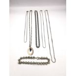 A collection of silver chains of varying length and a white metal rollerball link bracelet.