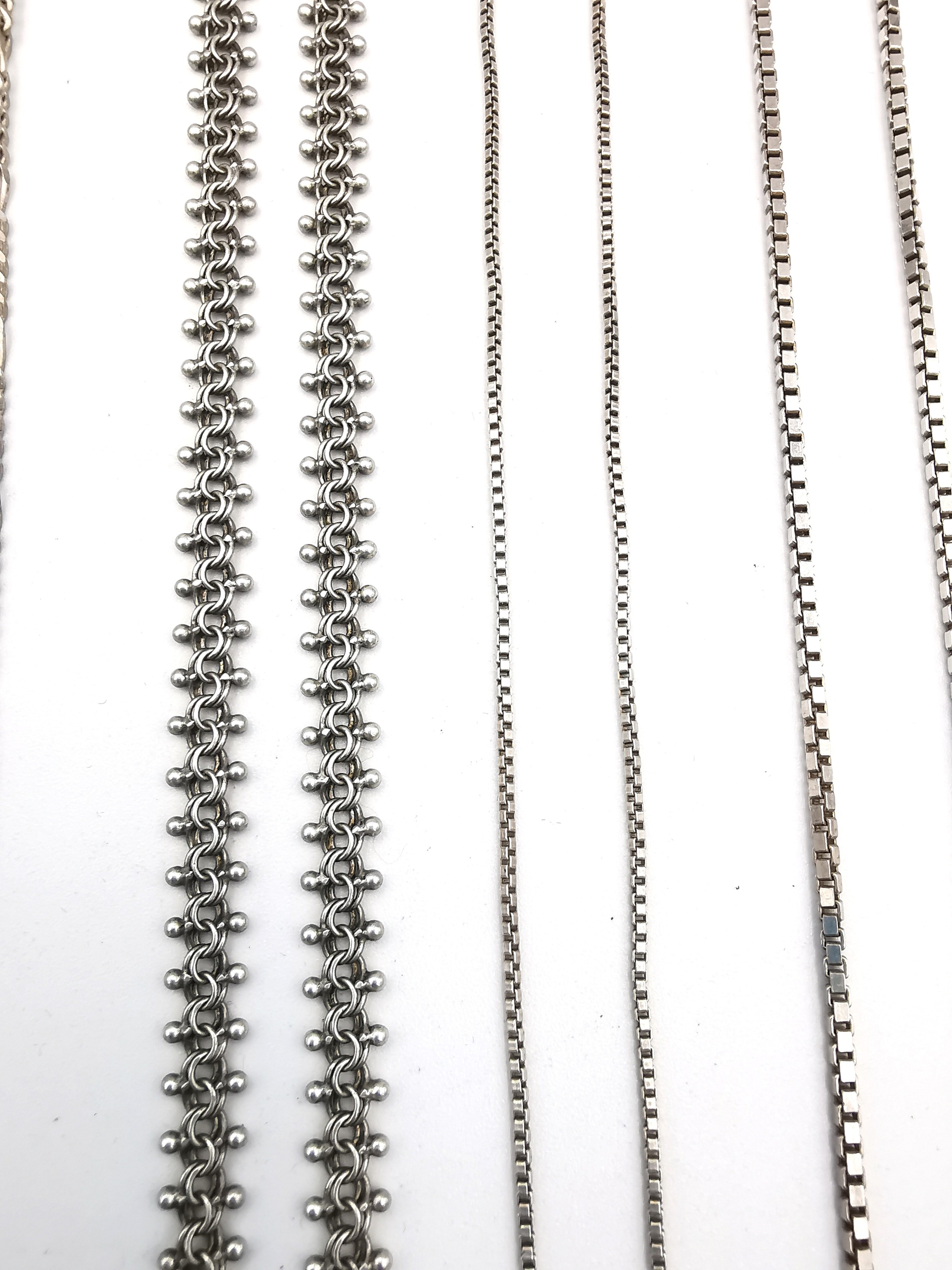 A collection of silver chains of varying length and a white metal rollerball link bracelet. - Image 3 of 4