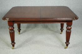 A late Georgian style mahogany extending dining table with two extra leaves and winding handle. H.77