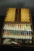 A vintage artist's oil paint box with fitted table top easel. H.9 W.40 D.30cm.