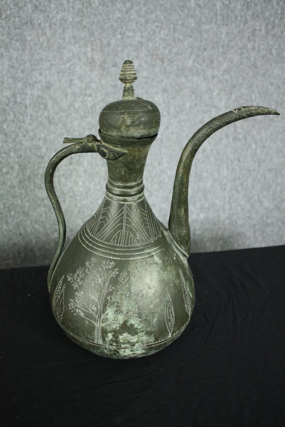 A 19th century Persian bronzed metal ewer with etched foliate and figural design along with a - Image 2 of 8