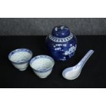 Two small blue and white Chinese tea bowls and spoons along with a blue and white Chinese prunus