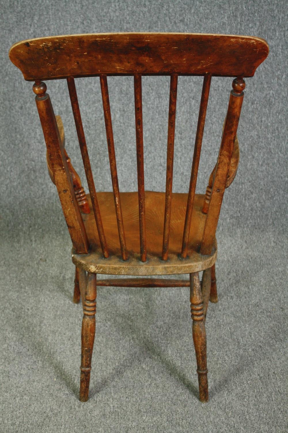 A 19th century elm seated stick back kitchen chair. - Image 4 of 5