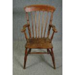 A 19th century elm seated stick back kitchen chair.