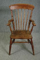 A 19th century elm seated stick back kitchen chair.