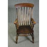 A 19th century elm seated stick back kitchen chair.