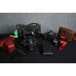 Two vintage cameras; Nikon and Canon along with various accessories. H.15 W.25cm. (largest).