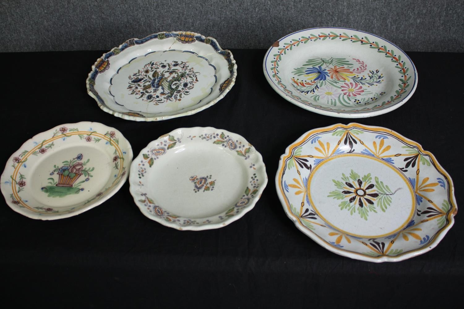 A collection of 19th century faience plates. One damaged. Dia.34cm. (largest).