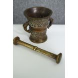 A 19th century Dutch bronze mortar and a brass pestle. L.18cm. (largest).