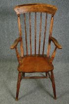 A 19th century elm seated stick back kitchen chair.