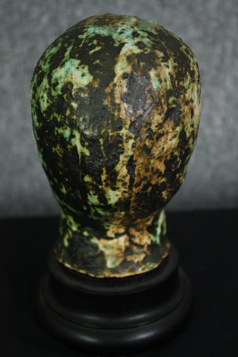A ceramic glazed bust; man's head on ebonised socle. H.23cm. - Image 4 of 5