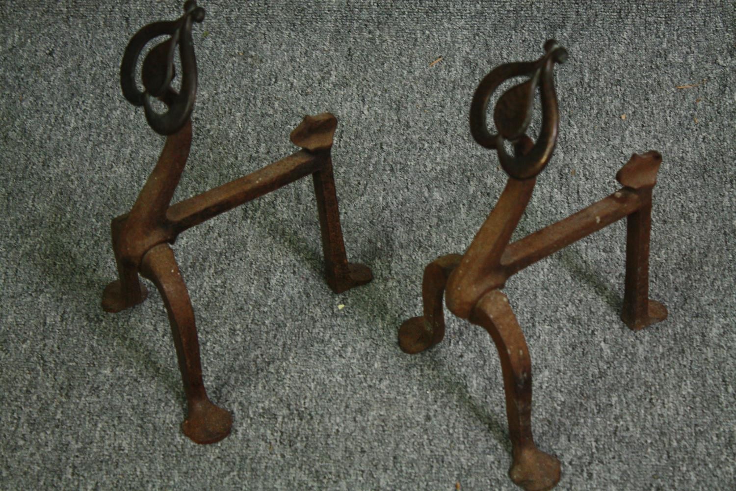 A pair of late 19th century Art Nouveau iron fire dogs and an iron doorstop. H.34cm. (largest). - Image 2 of 4