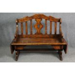 A Continental walnut bench with (unusual) drop flaps to each end. H.105 W.107 D.51cm.