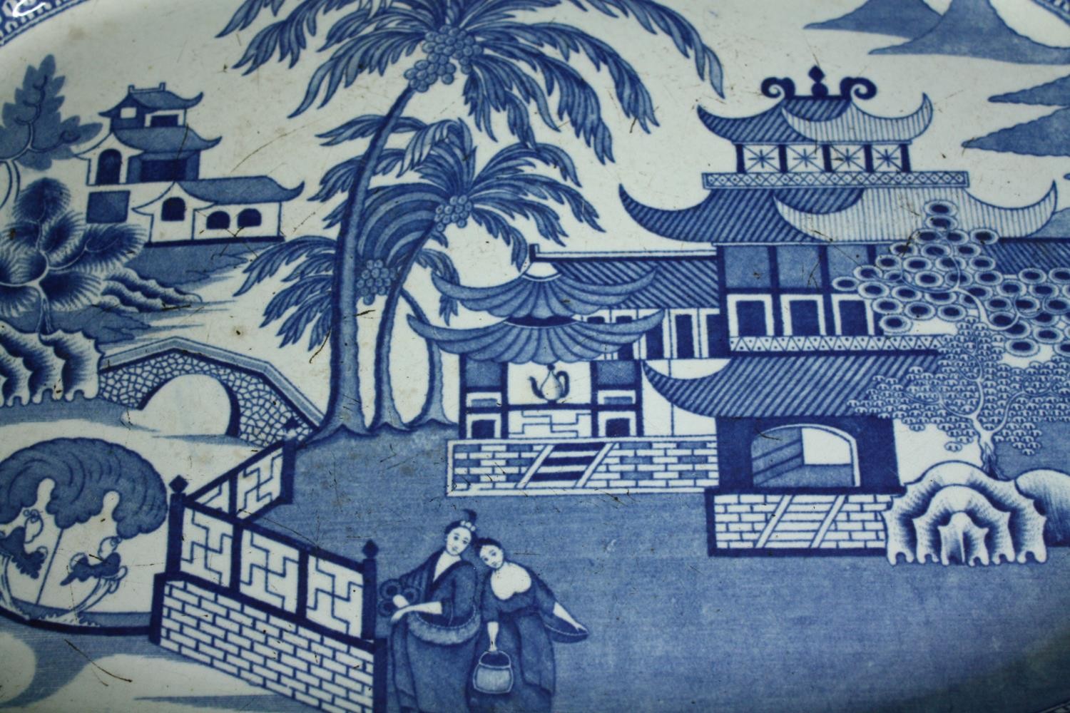 A large 19th century blue and white transfer printed serving platter with oriental figures in a - Image 3 of 5