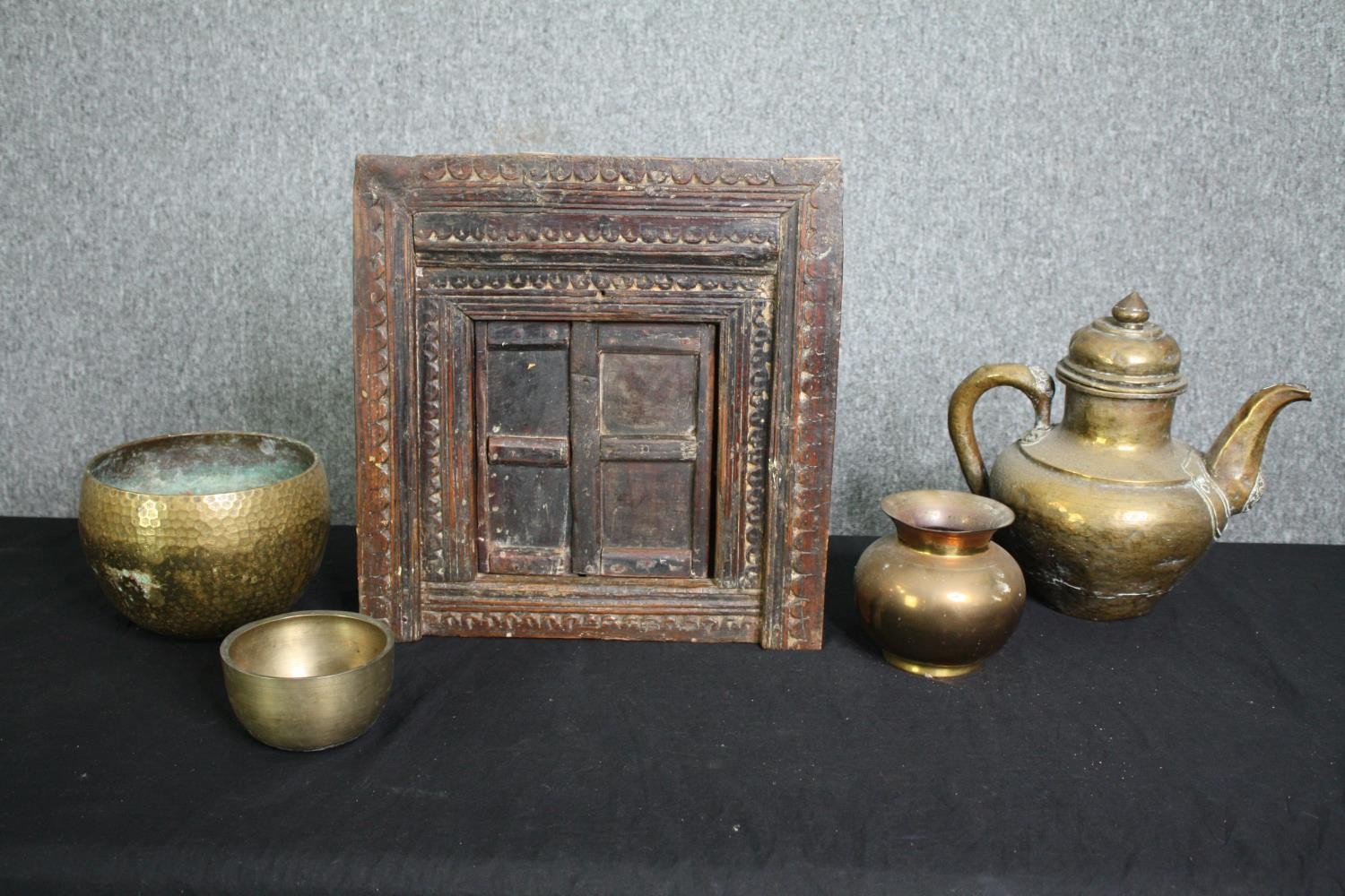 A collection of Eastern brassware and a carved hardwood framed with hinged door. H.40 W.38cm. (