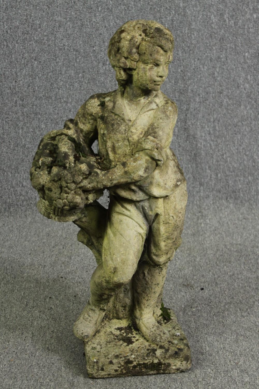 A composite garden statue of a young boy. H.77cm.