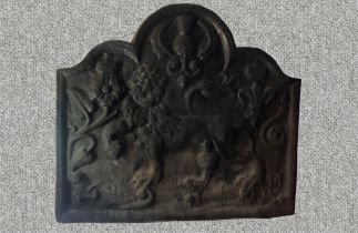 A cast iron fire back in the 17th century style with lion, rose, thistle and fleur-de-lys motifs.