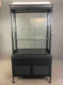 A contemporary two section shop display cabinet. H.211 W.106 D.51cm.