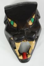 A carved and painted black panther head mask. H.35cm.