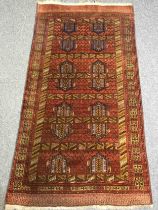 A Shirvan carpet, burgundy field within stylised multiple borders. L.190 W.102cm.