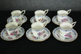 A set of six early 19th century Coalport tea cups and saucers, hand decorated in gilt and with