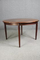 A vintage rosewood dining table with extra leaf. H.74 Dia.122cm.