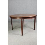 A vintage rosewood dining table with extra leaf. H.74 Dia.122cm.