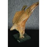 A carved wooden figure of a diving hawk on a marble base. H.35cm.