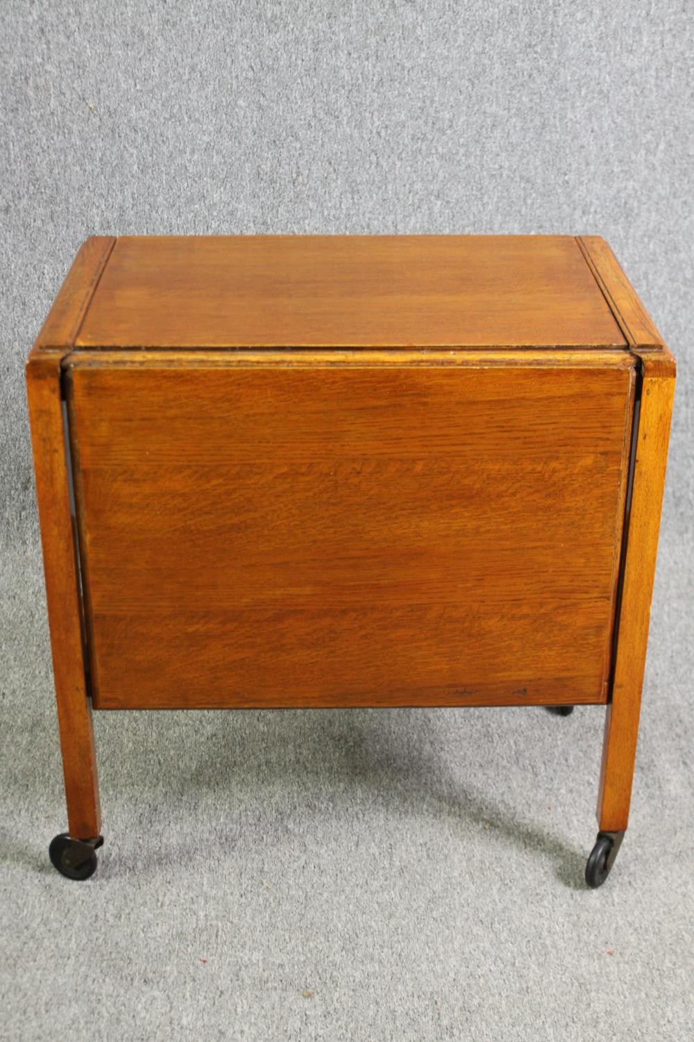 A mid century light oak serving or drinks trolley with spring action drop side. H.66 W.80 D.64cm. - Image 2 of 7