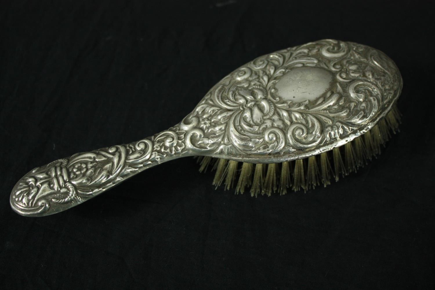 A silver repousse dressing set with foliate and floral design. A mirror and two brushes. Hallmarked: - Image 2 of 5